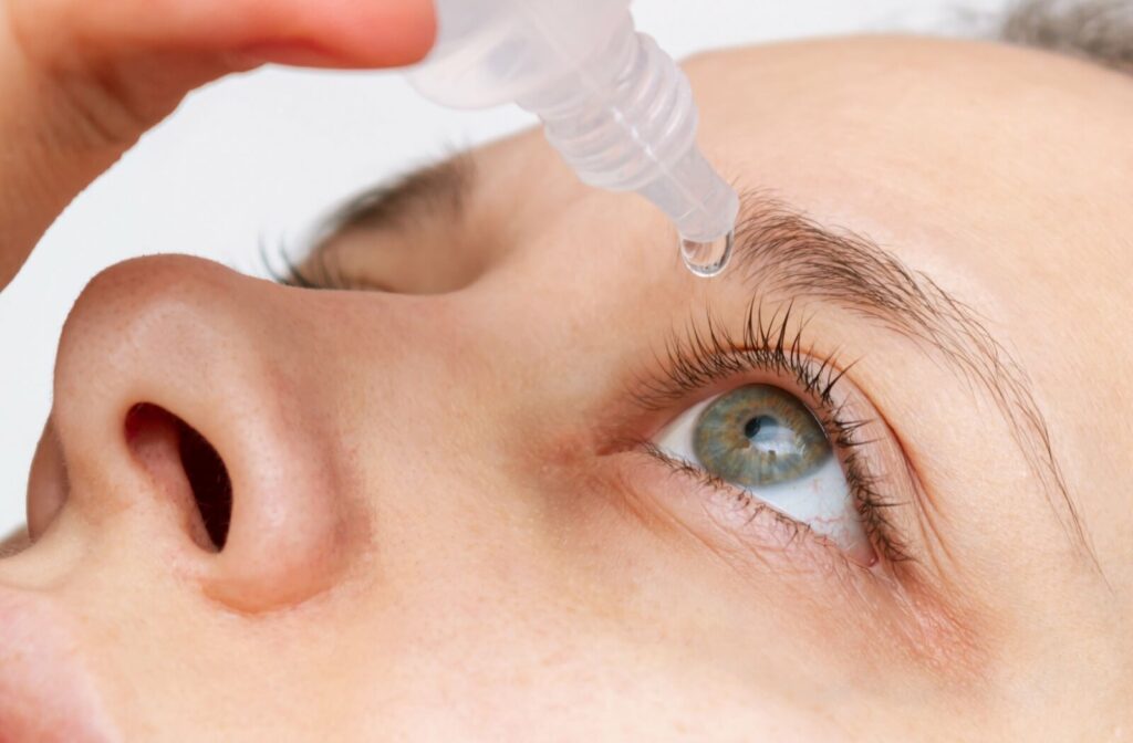 A close up of a woman putting in a contact lens with dry eyes.