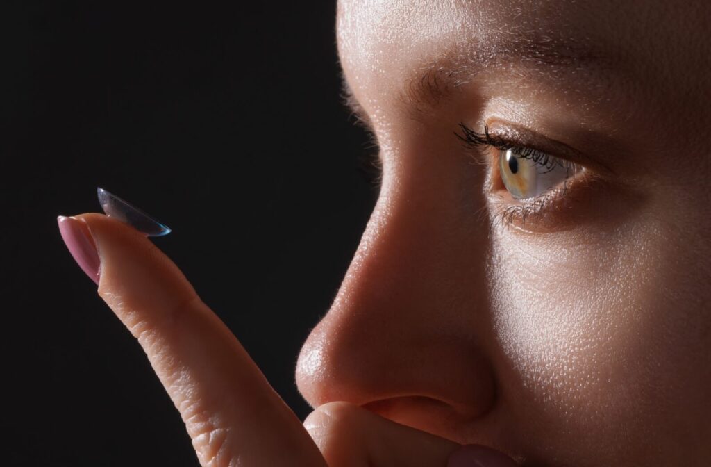 A close-up of a person examining a contact lens placed carefully on their index finger